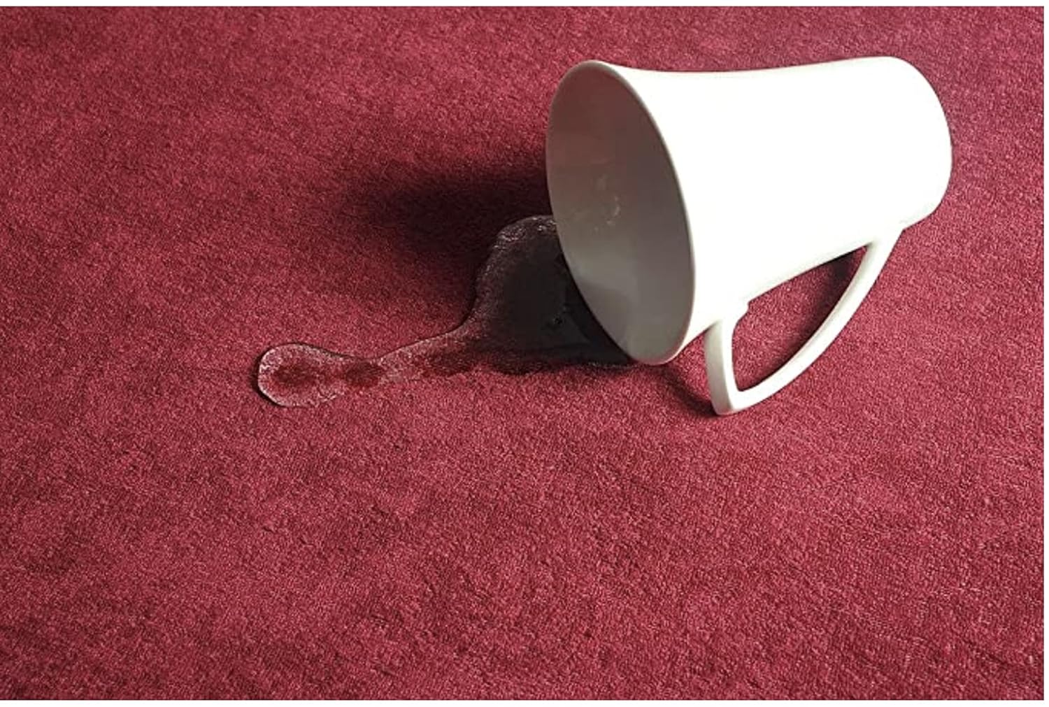 White cup with a spill on a red water proof mattress protector